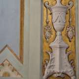 Mentre le pareti conservano una decorazione con foglie e piante rampicanti dorate che cingono vasi bianchi...